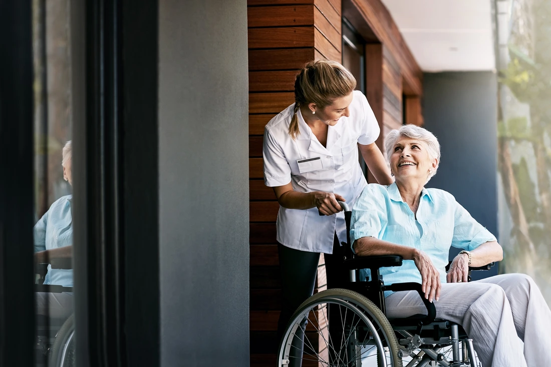 Nurse, talking and senior woman on wheelchair for support or rehabilitation of medical healthcare patient Happy caregiver, retirement or person with disability at home for recovery, wellness or help