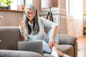 older female waving to doctor on laptop