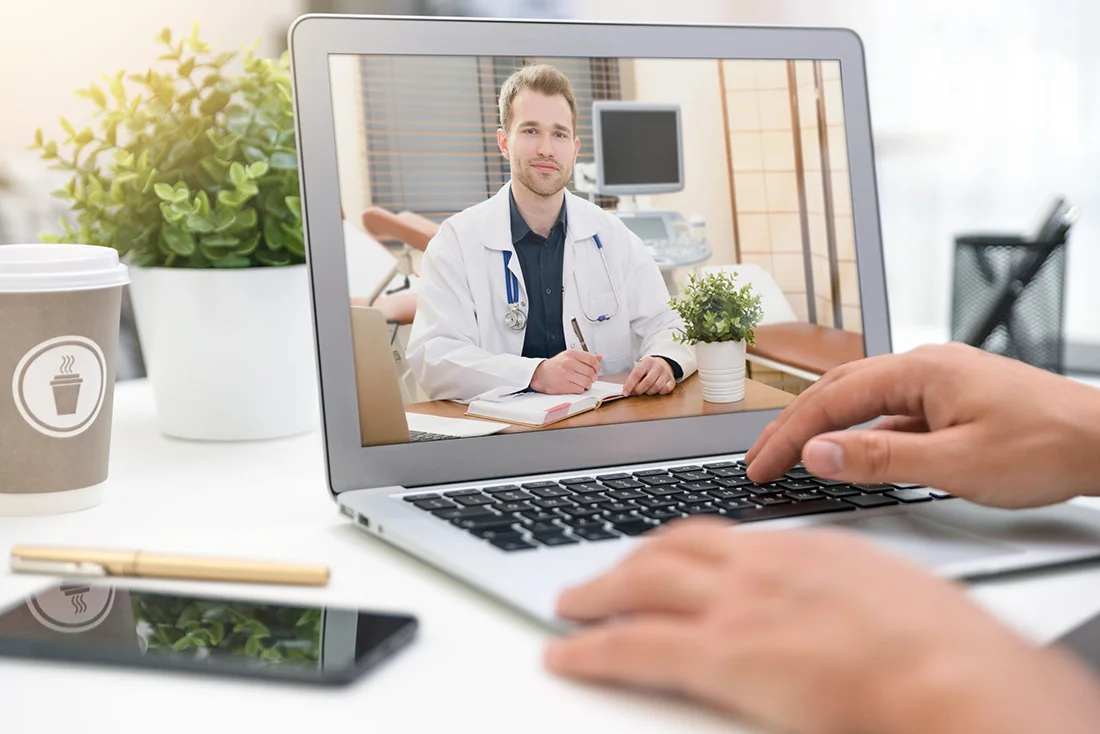 Doctor with a stethoscope on the computer laptop screen Telemedicine or telehealth concept