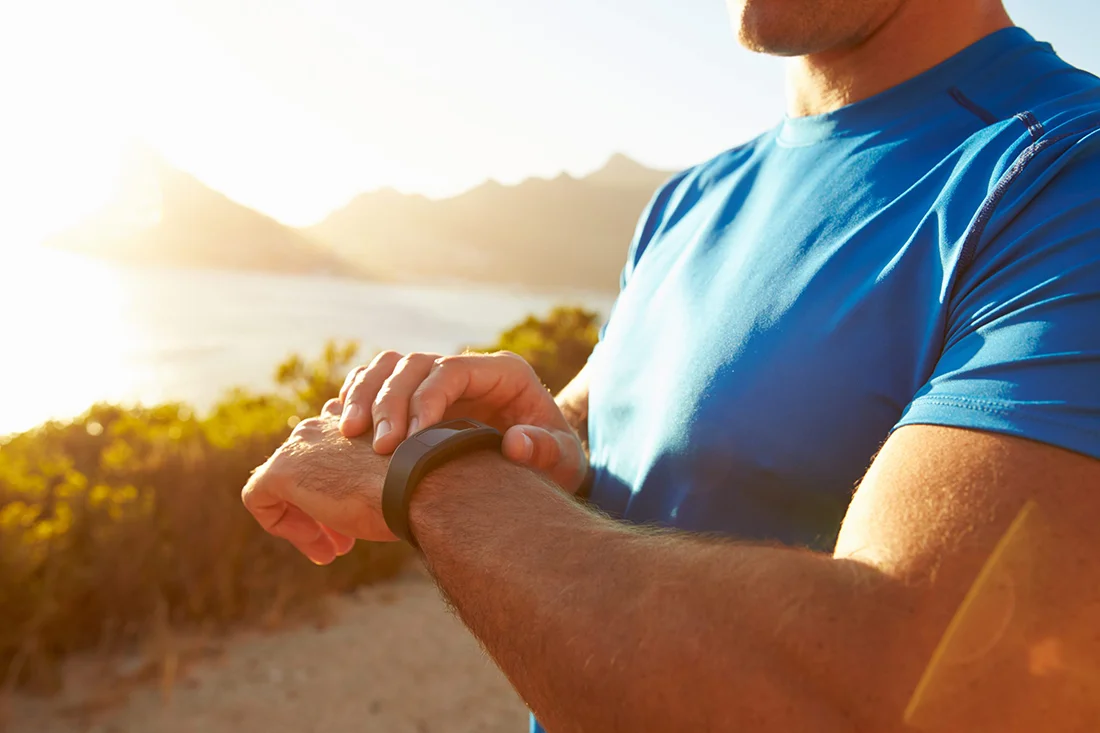 Young man checking time on his sports watch