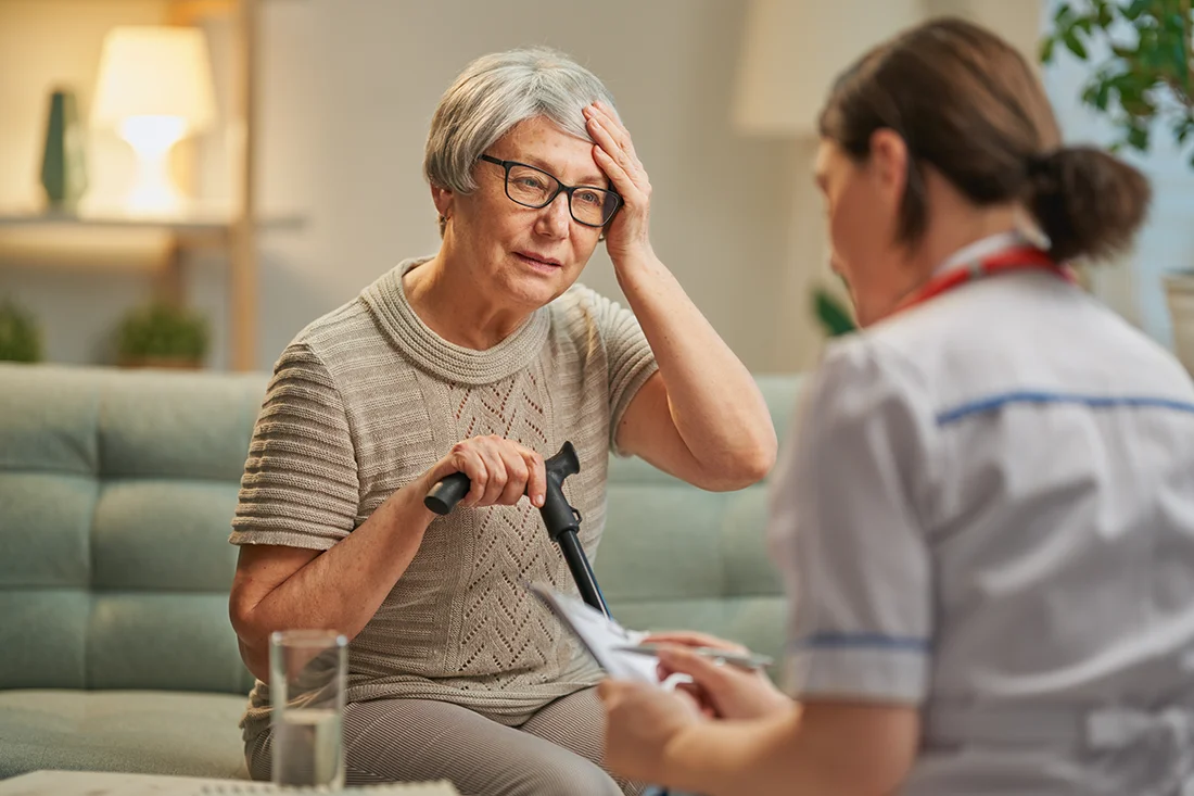 Elderly patient and caregiver spending time together Senior woman holding cane