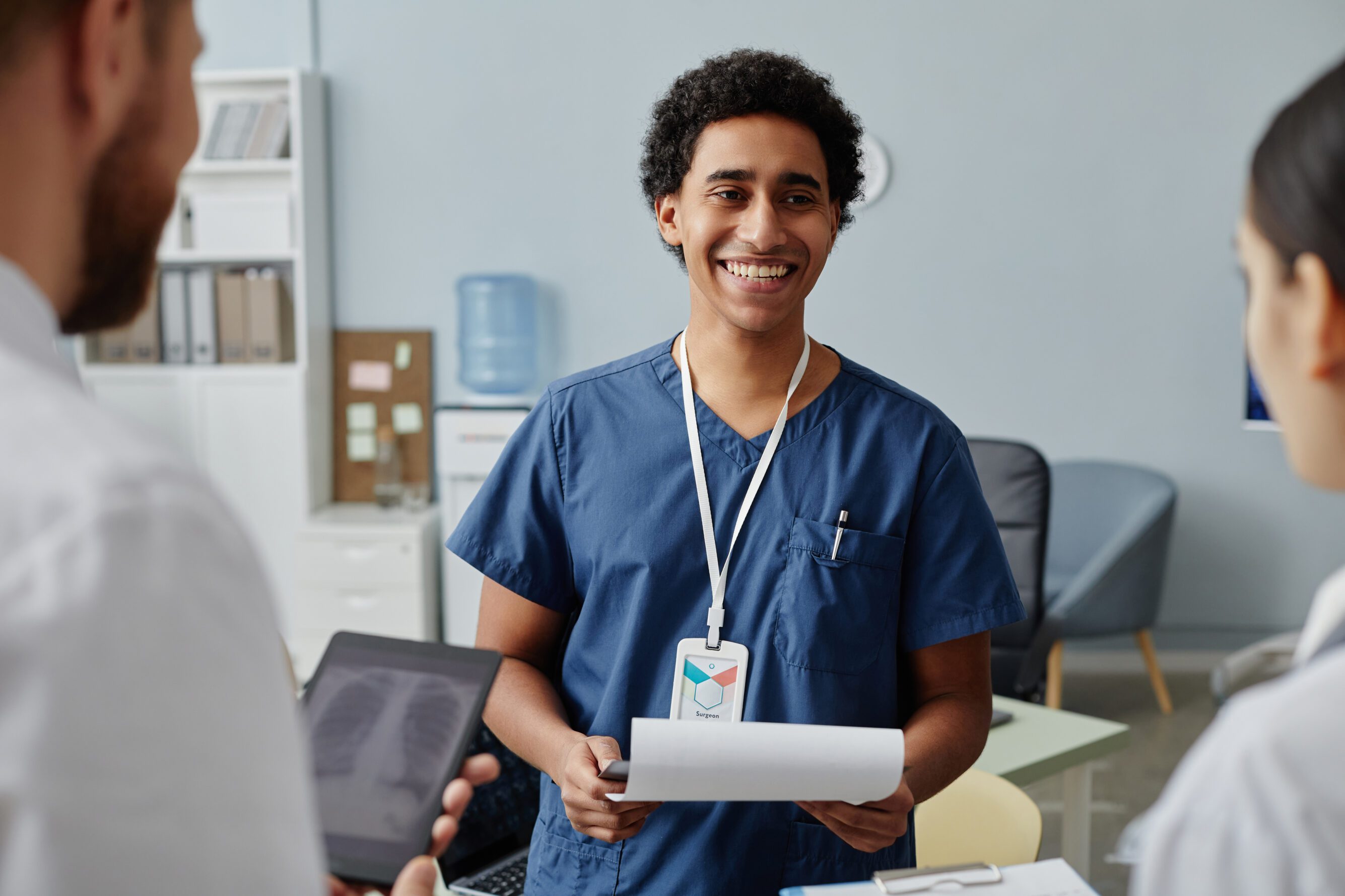 young medical intern talking to group of doctors