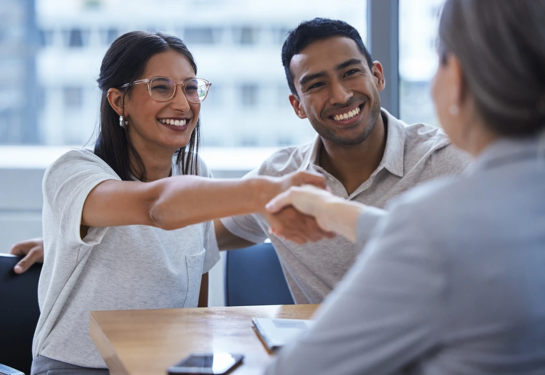 Couple, happy and handshake with financial consultant for deal, agreement or contract Smile, man and woman shaking hands of broker for finance, loan or mortgage, welcome and thank you for investment