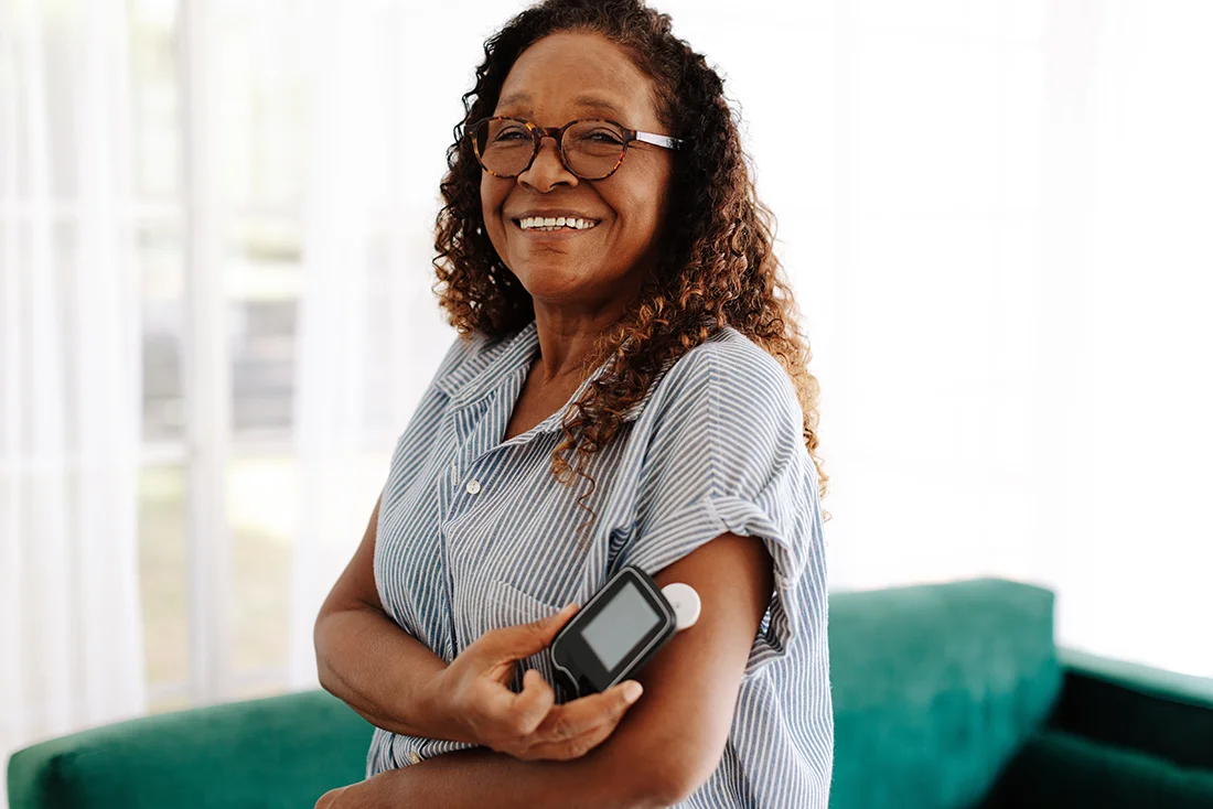 Diabetic woman using a flash glucose monitor to measure her blood sugar levels with a simple scan, allowing her to adjust her diet and medication as needed for optimal health and wellness